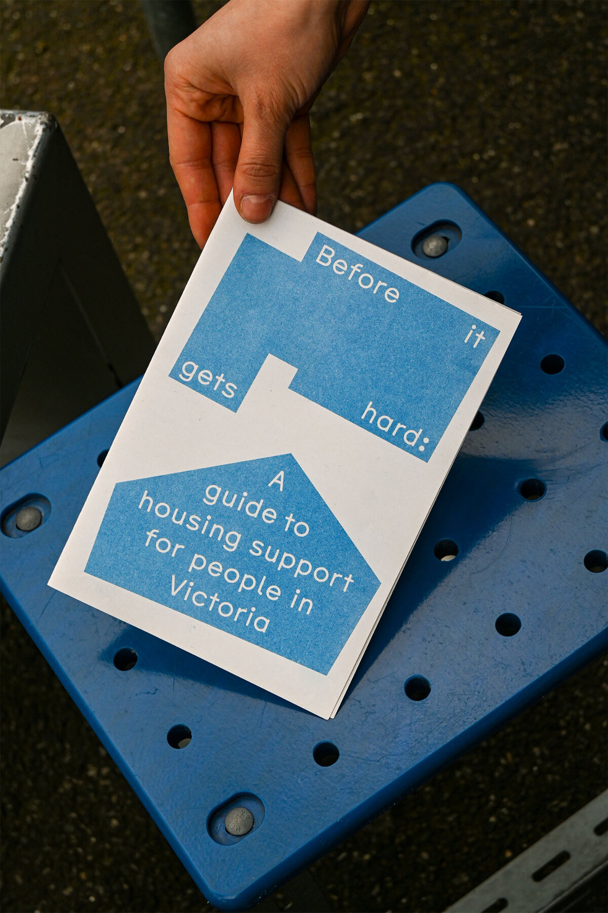 A hand holding the Before it gets hard housing support guide.
